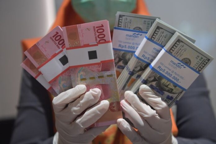 uang rupiah dan dolar AS di Bank Mandiri Syariah, Jakarta, Senin (20/4/2020). Foto Antara/Nova Wahyudi/wsj.